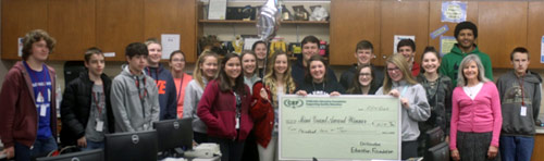 staff and students taking picture with big check