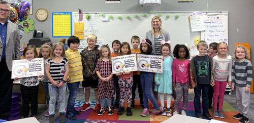 staff and students taking picture with an award