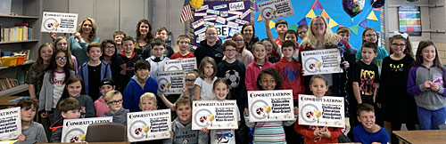 staff and students taking picture with an award