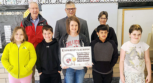 staff and students taking picture with award