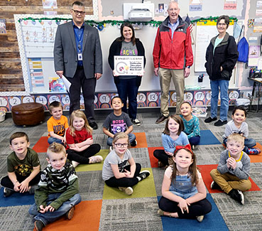 staff and students taking picture with award