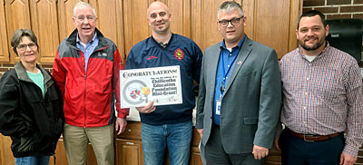 staff taking picture with award