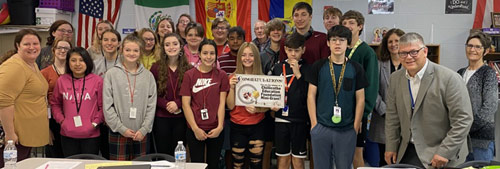 staff and students taking picture with award