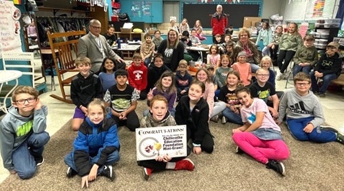 staff and students taking picture with award