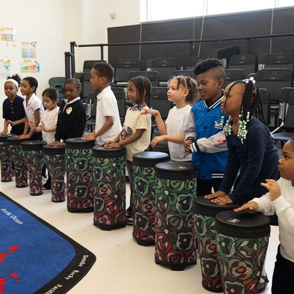 Children playing drums in music class