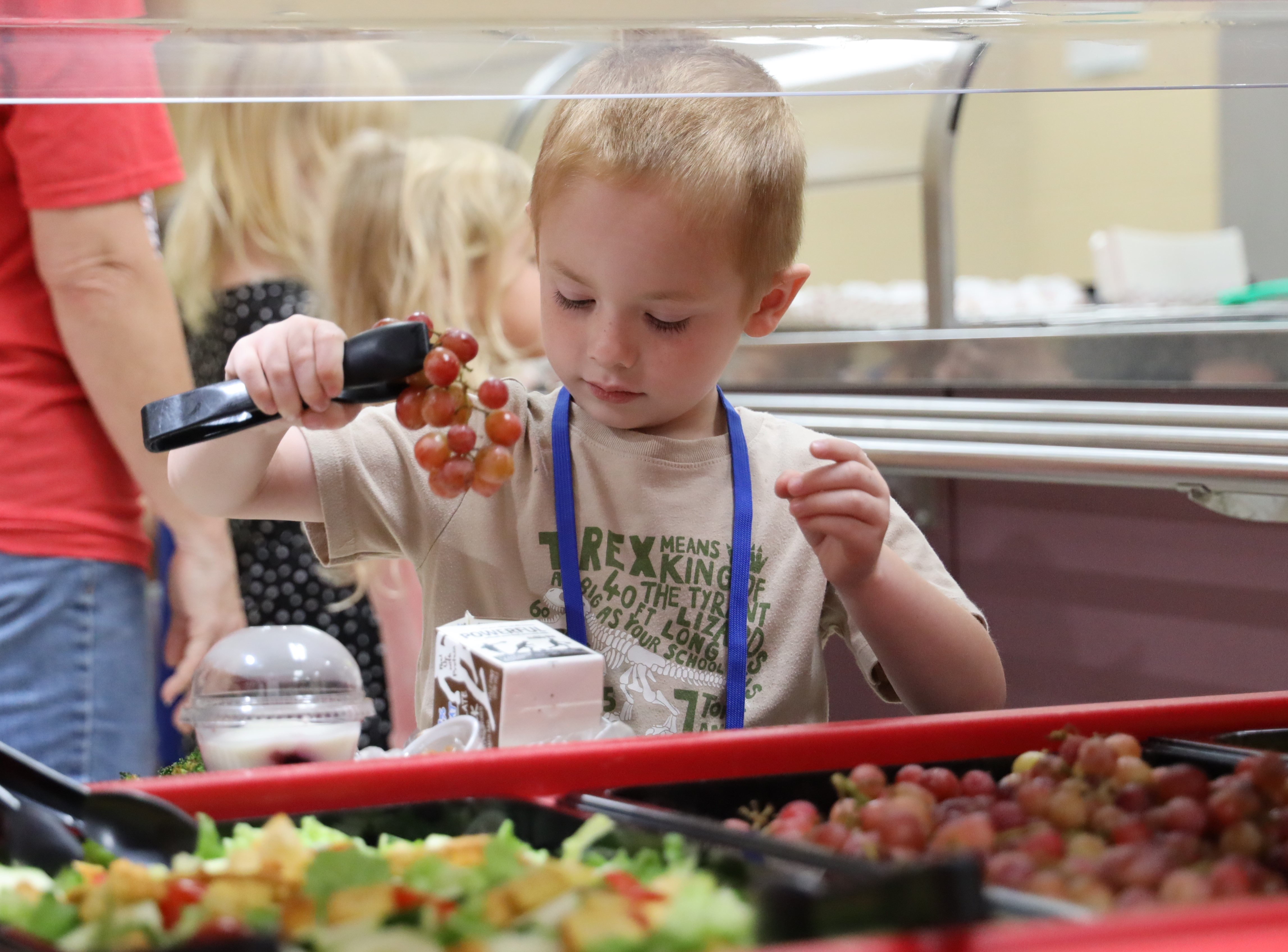 student picking up grapes with tongs