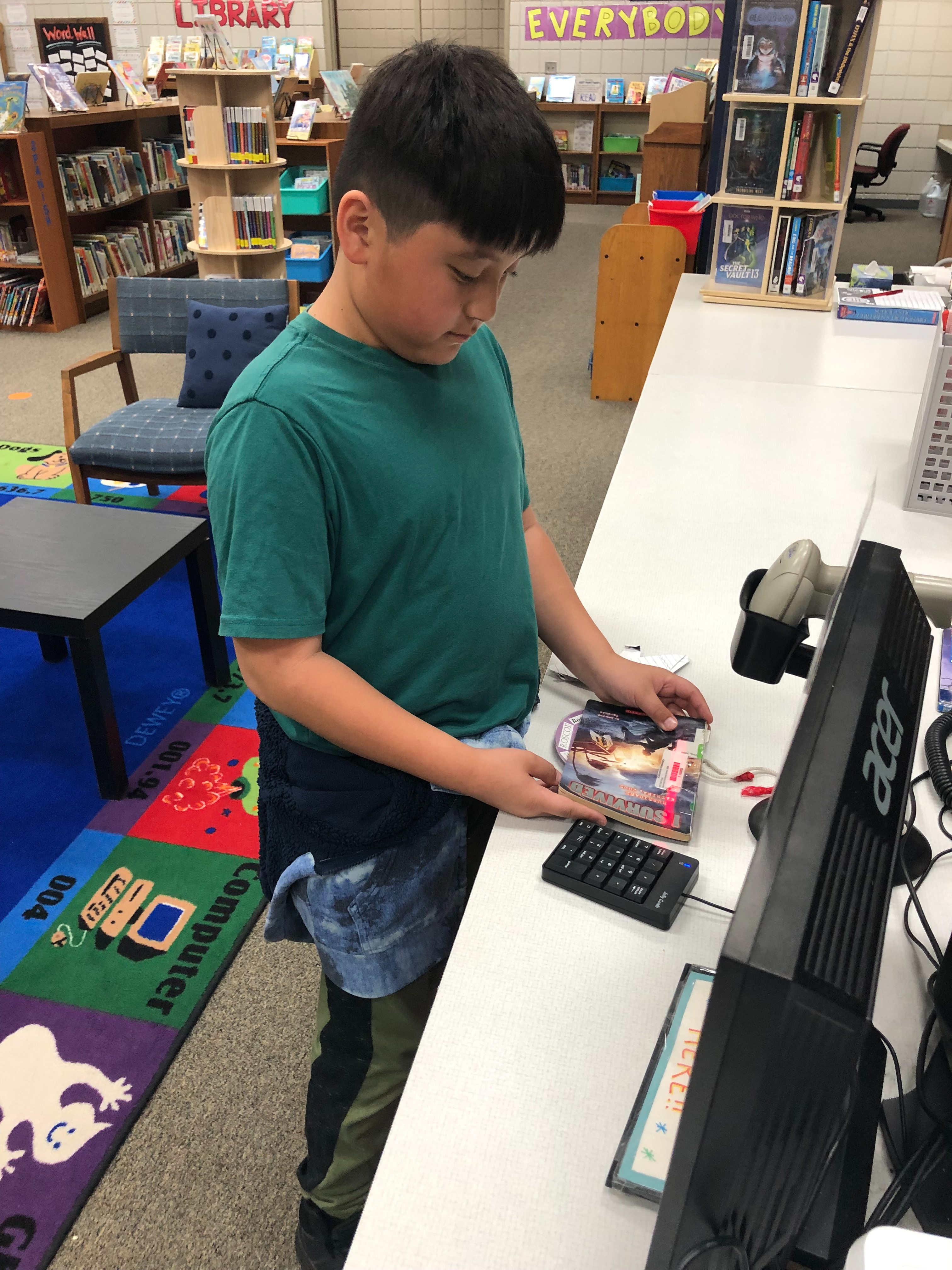 student is checking out a book in the library.  Please see comments below.