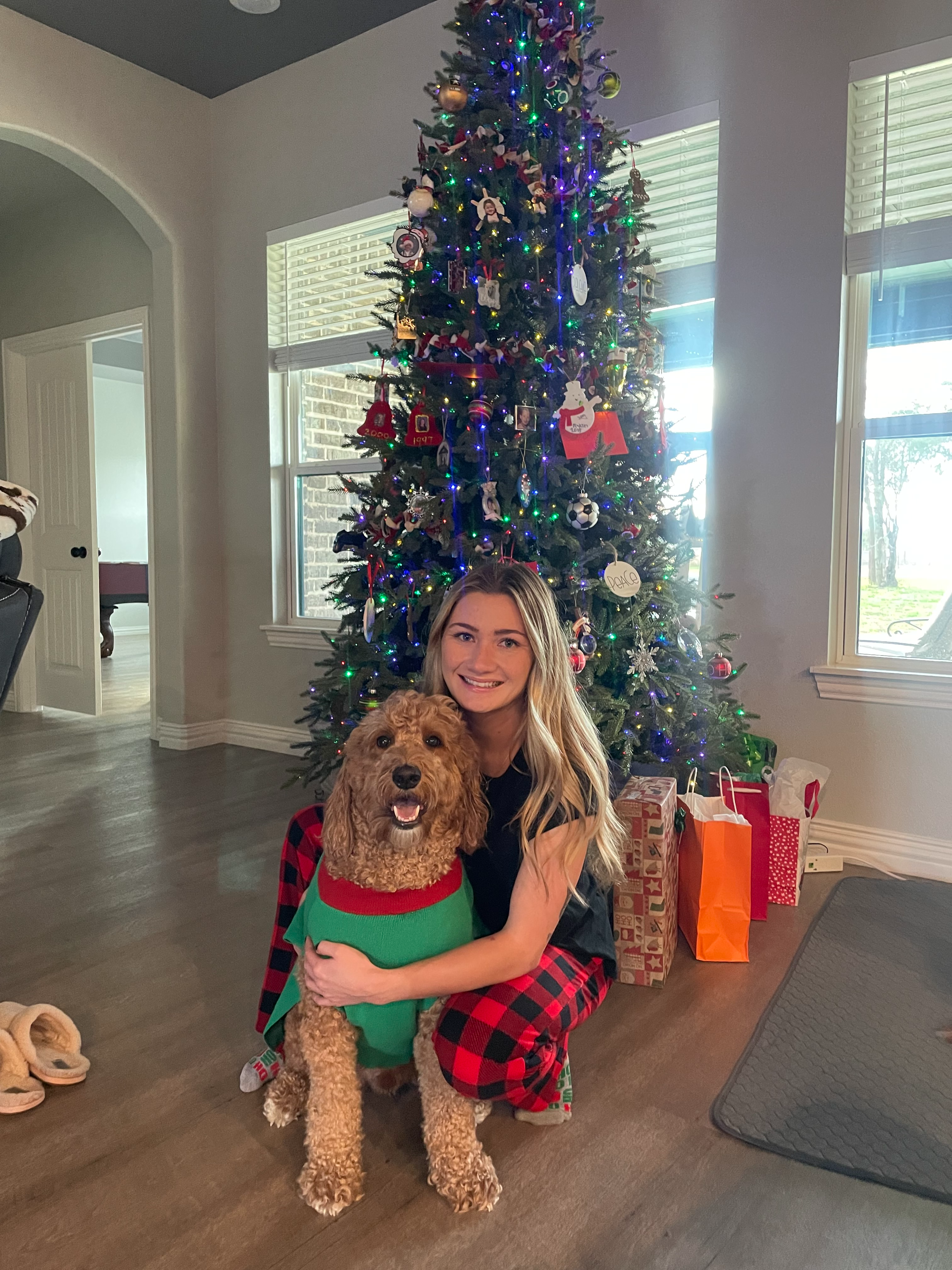 Miss. Brown and her goldendoodle in front of a Christmas  tree