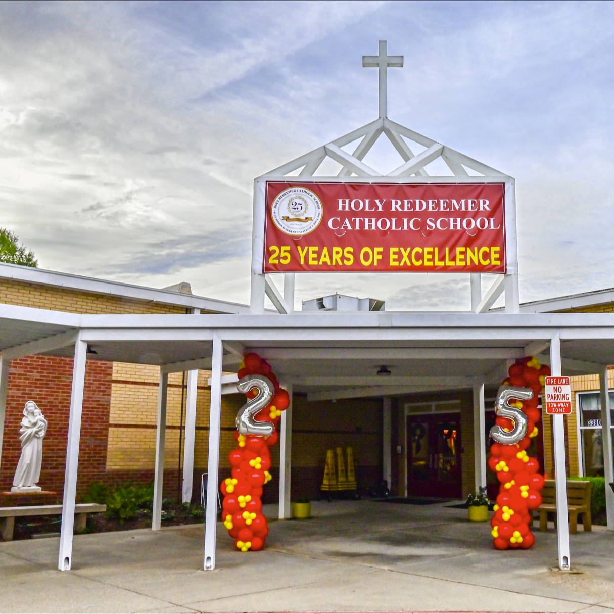 Image of front of Holy Redeemer Catholic School with 25th anniversary decor including yellow and red ballon garland 