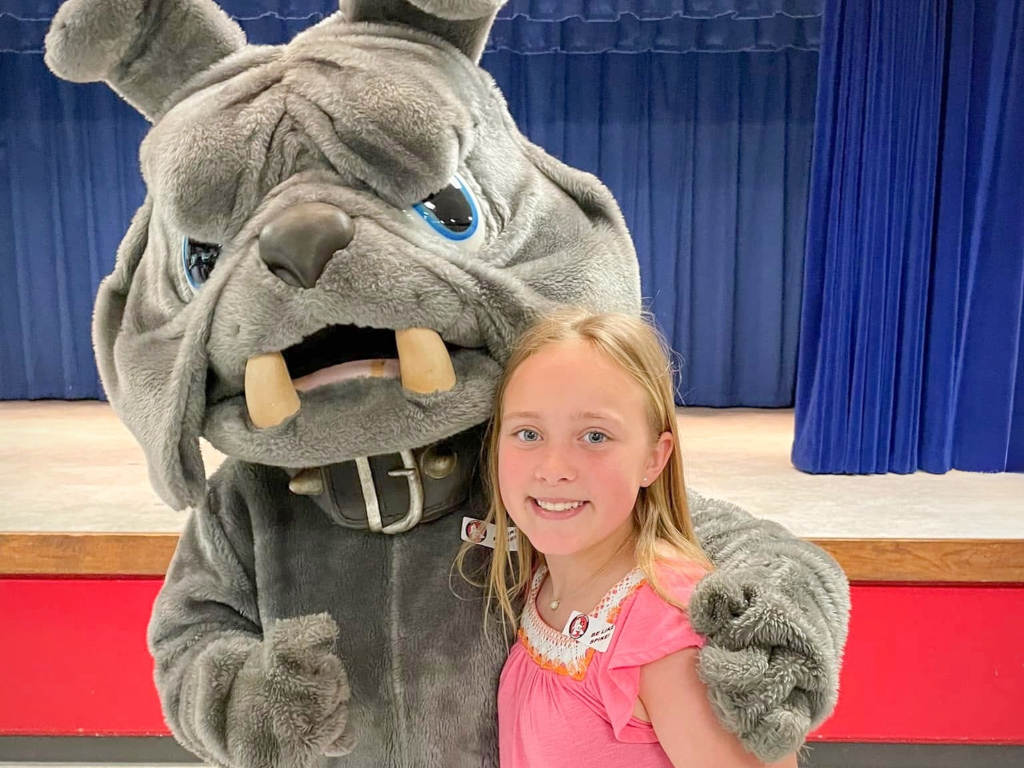 Spike our Bulldog Mascot Hugs a Student