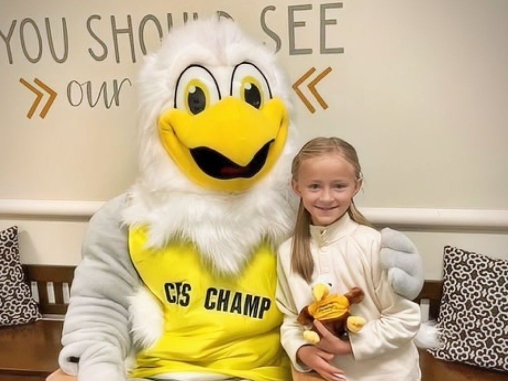 Champ the CES Eagle Hugs a Student