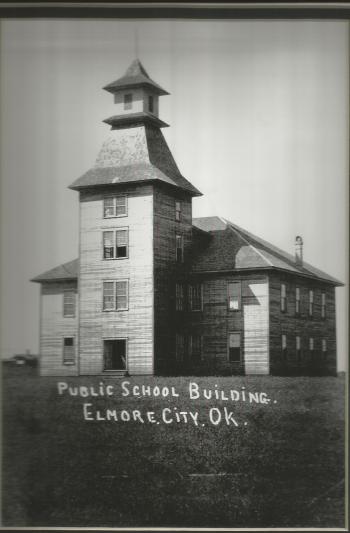 A black and white photo of the first school building of the district.