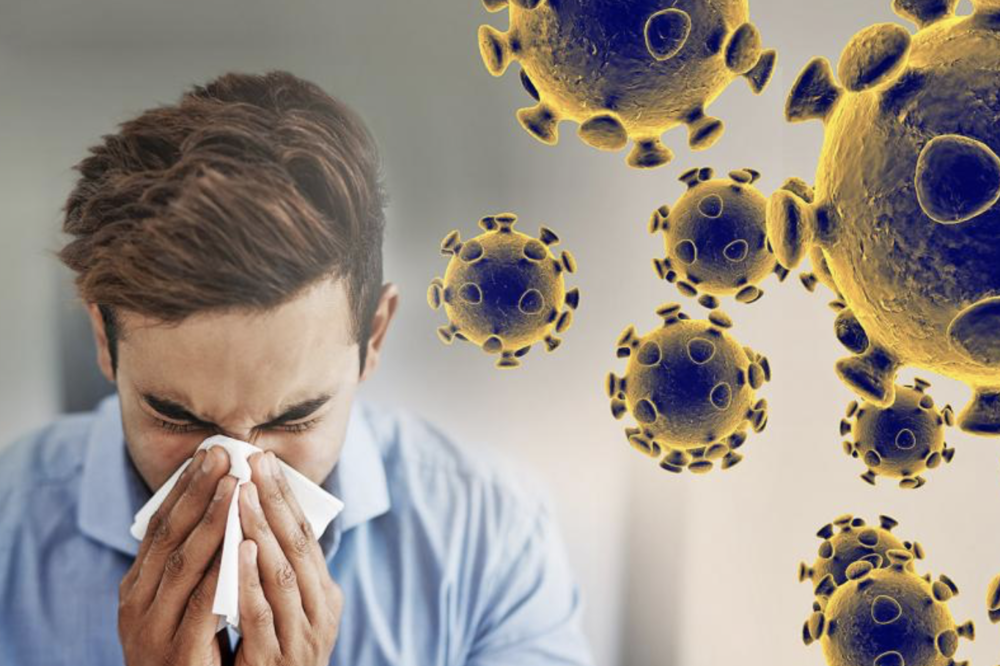 man sneezing into tissue with coronavirus molecules beside him