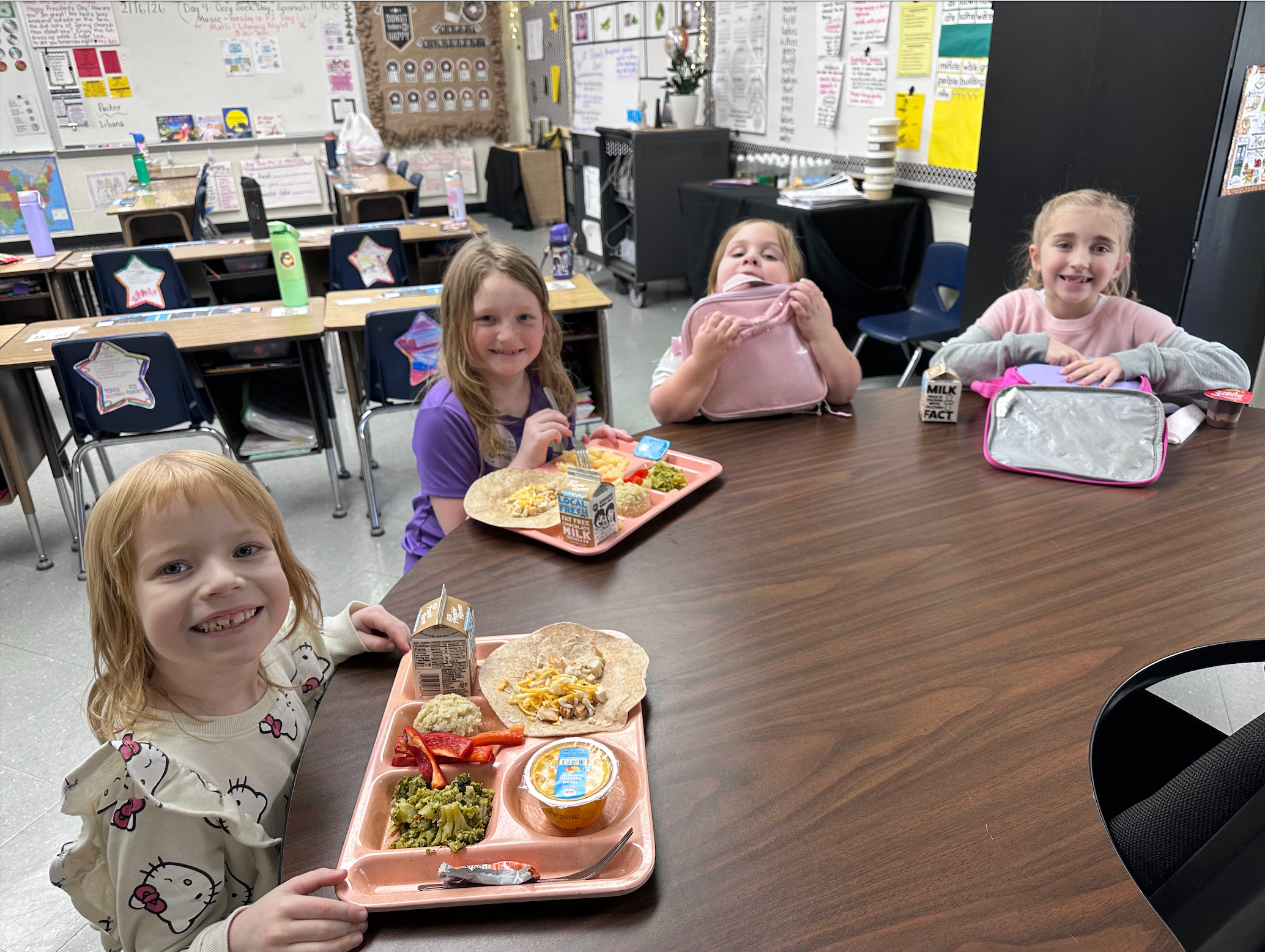 Students eating lunch together at a classroom table