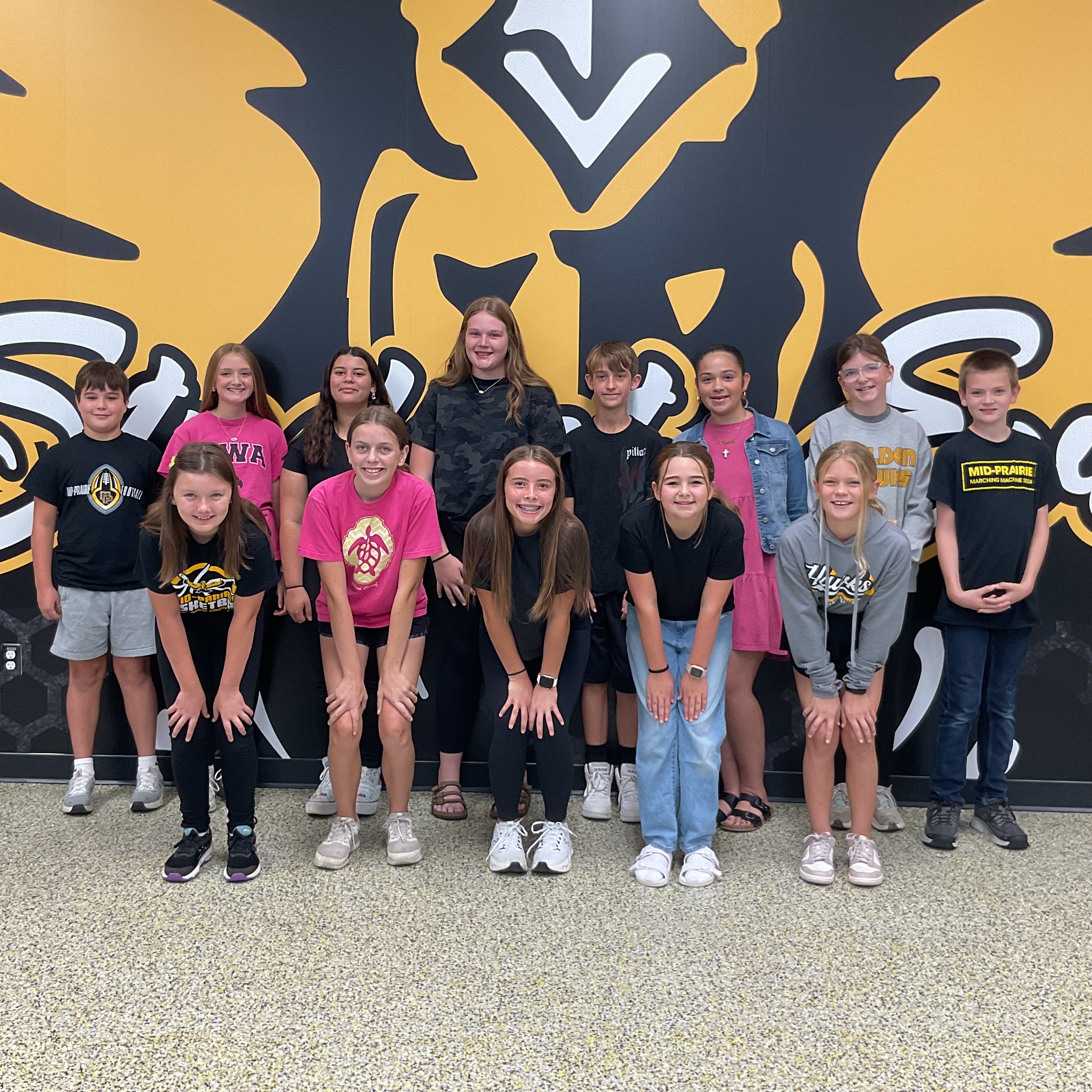 Group of students standing in front of the Golden Hawk logo that says Every Student, Every Day