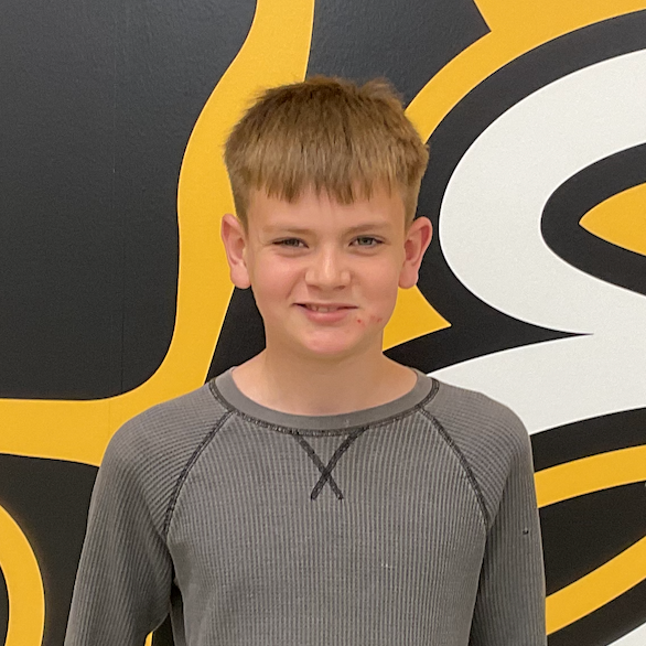 Calvin Wunderlich wearing brown shirt in front of the MP Hawk wall decal