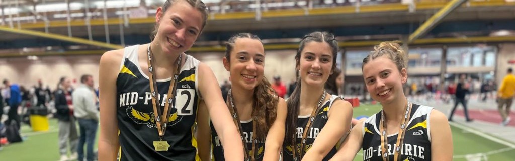 Four girls track relay team members holding the baton out front