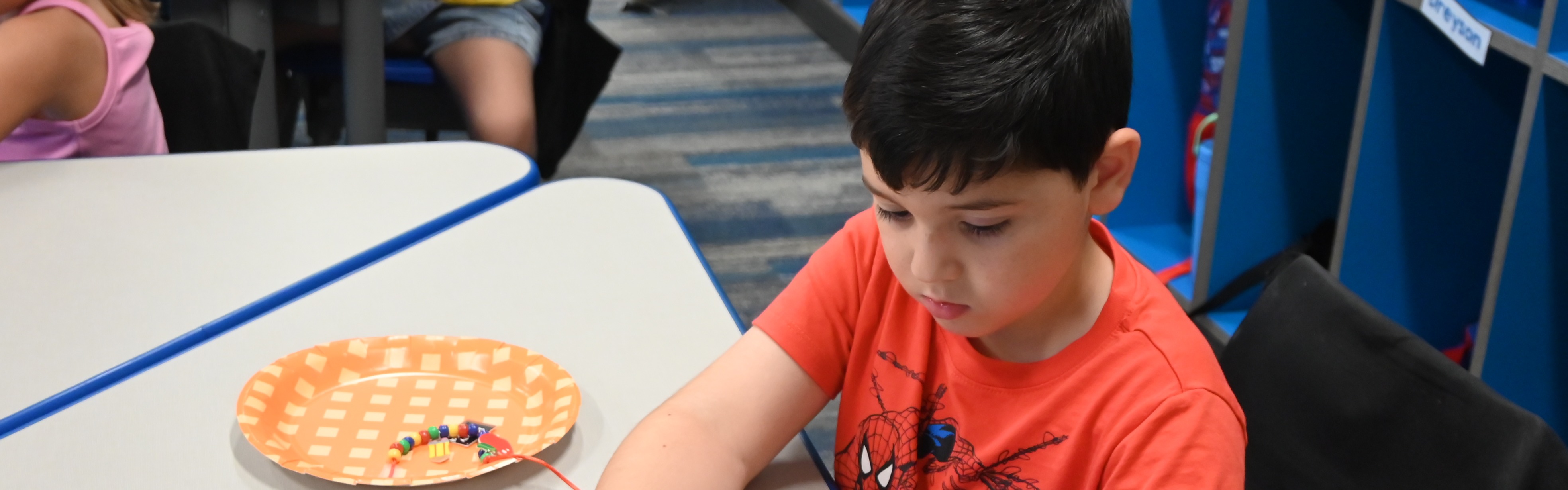 kindergarten student sitting at classroom desk