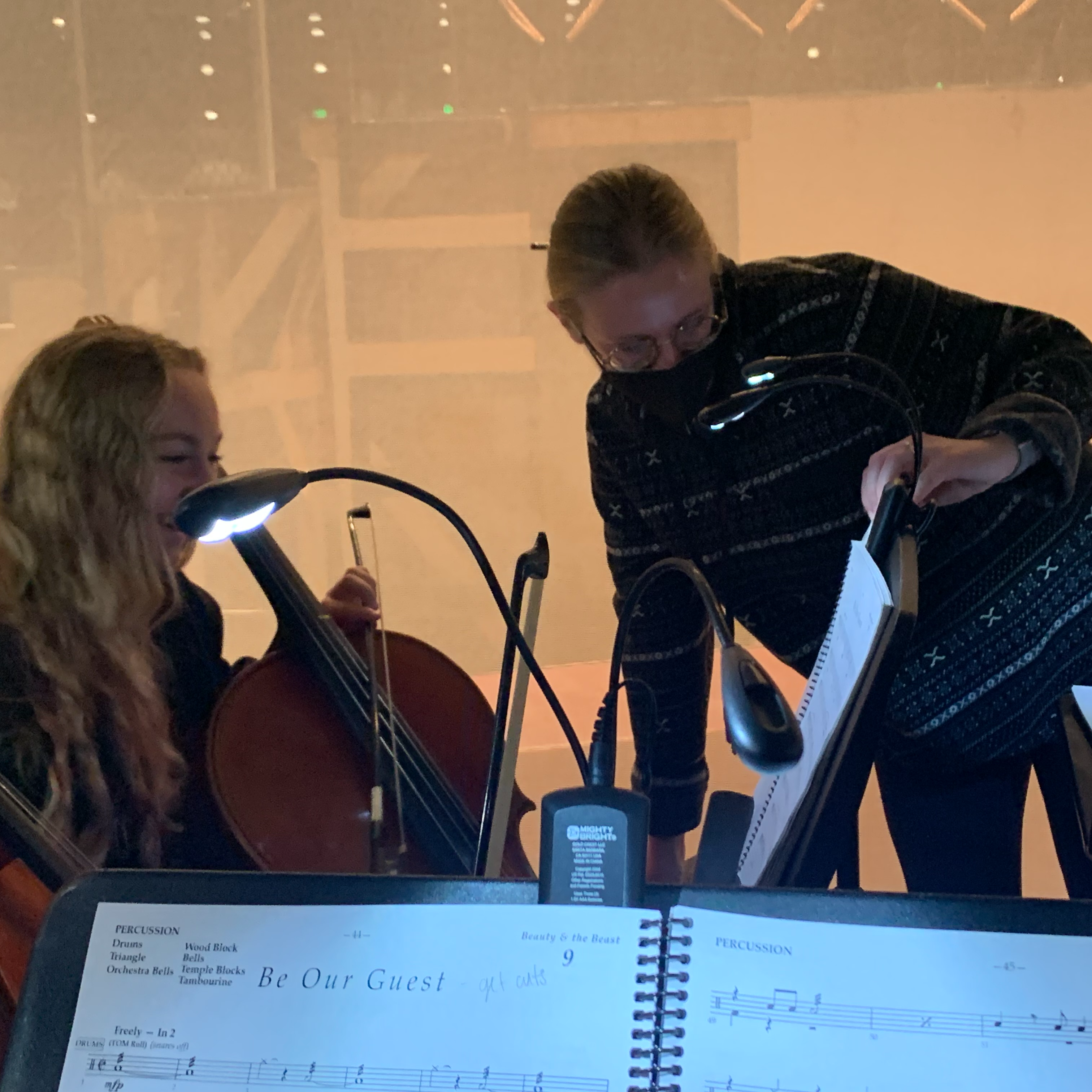 Teacher NaKatie Hoaglund working with an orchestra student backstage in the orchestra pit