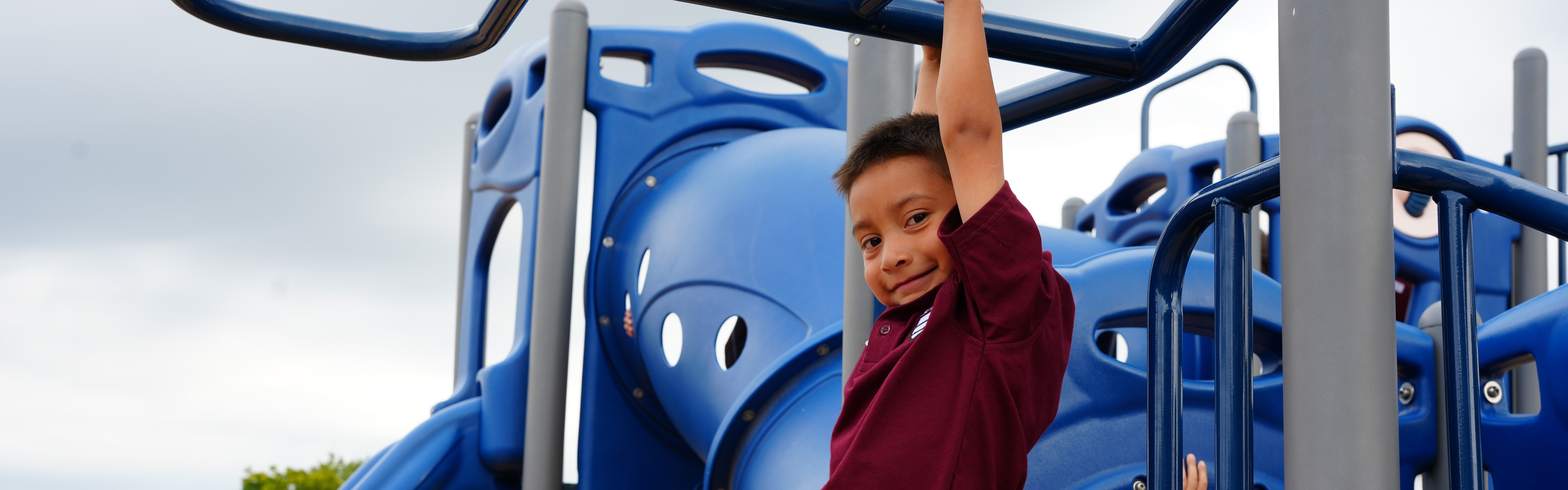 student swinging on the monkey bars