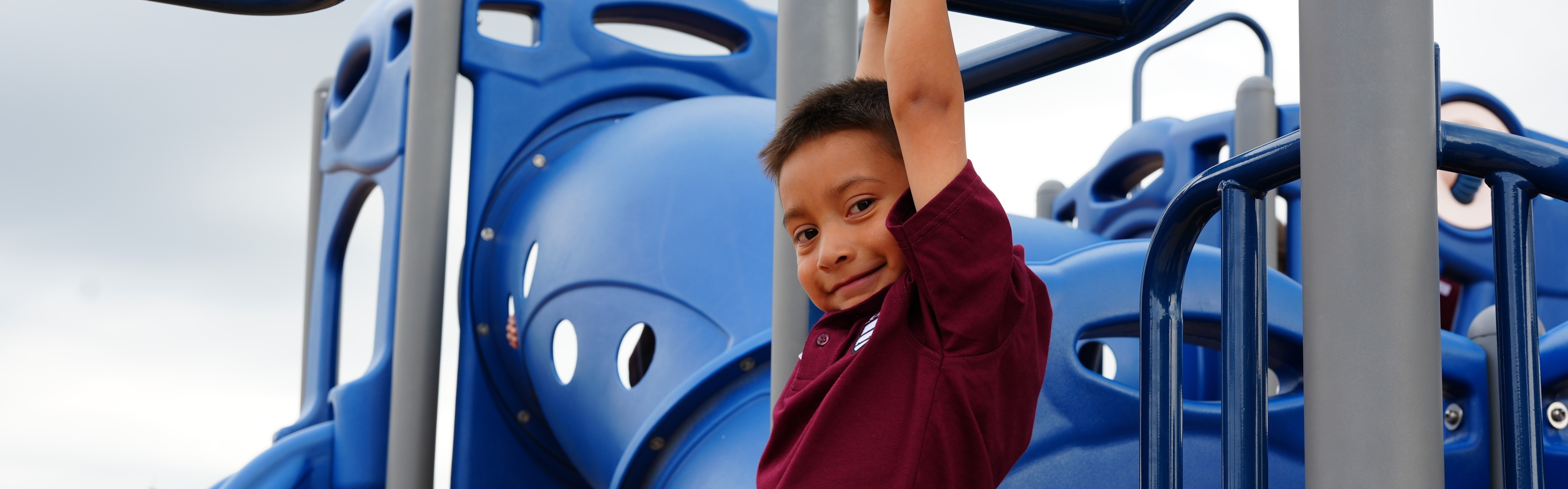 student swinging on the monkey bars