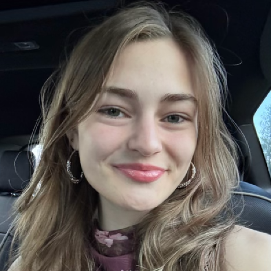 Lydia close-up headshot photo sitting in the car with hair down and smiling