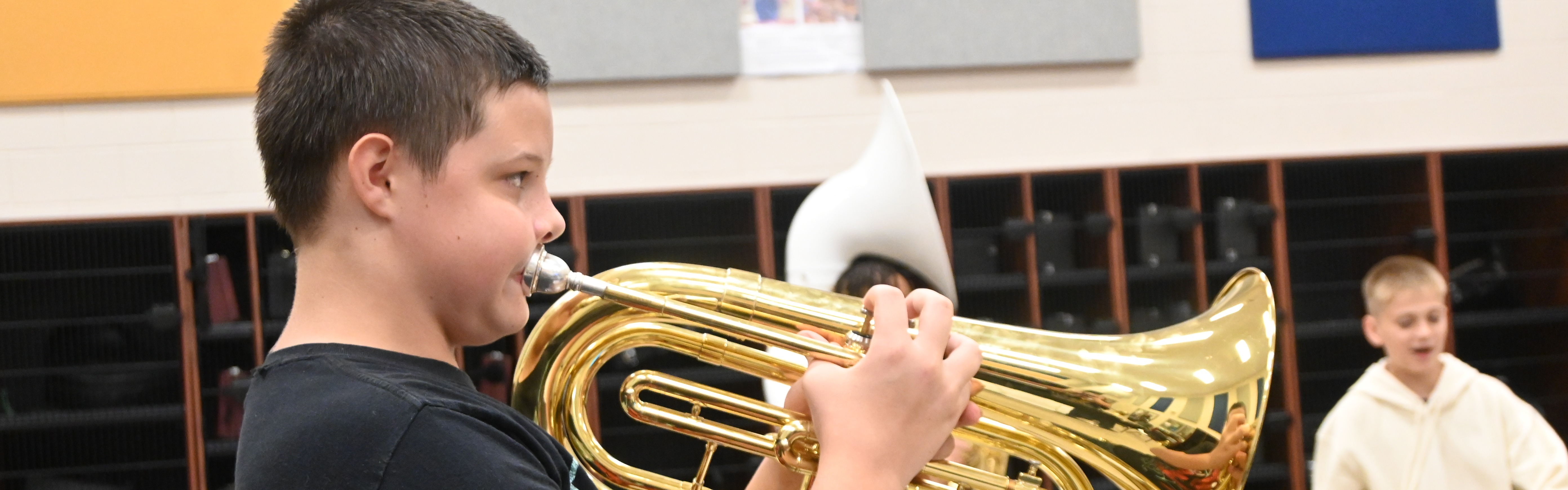 student in band using his brass instrument