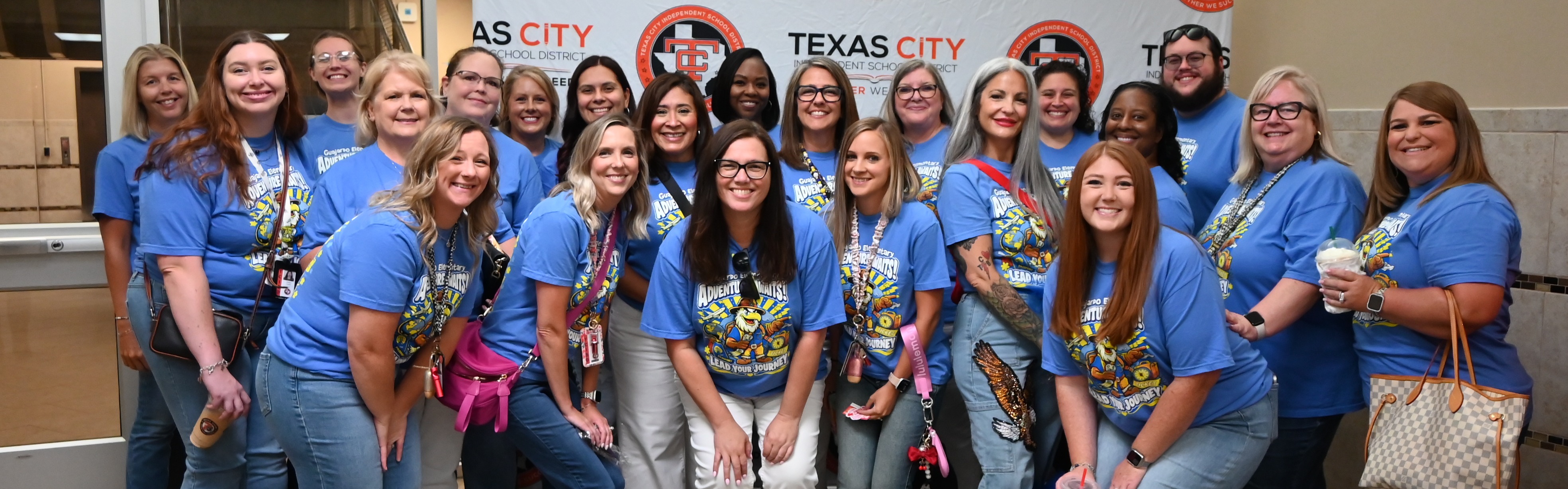 huge group of teachers wearing blue Guajardo Elementary t-shirts