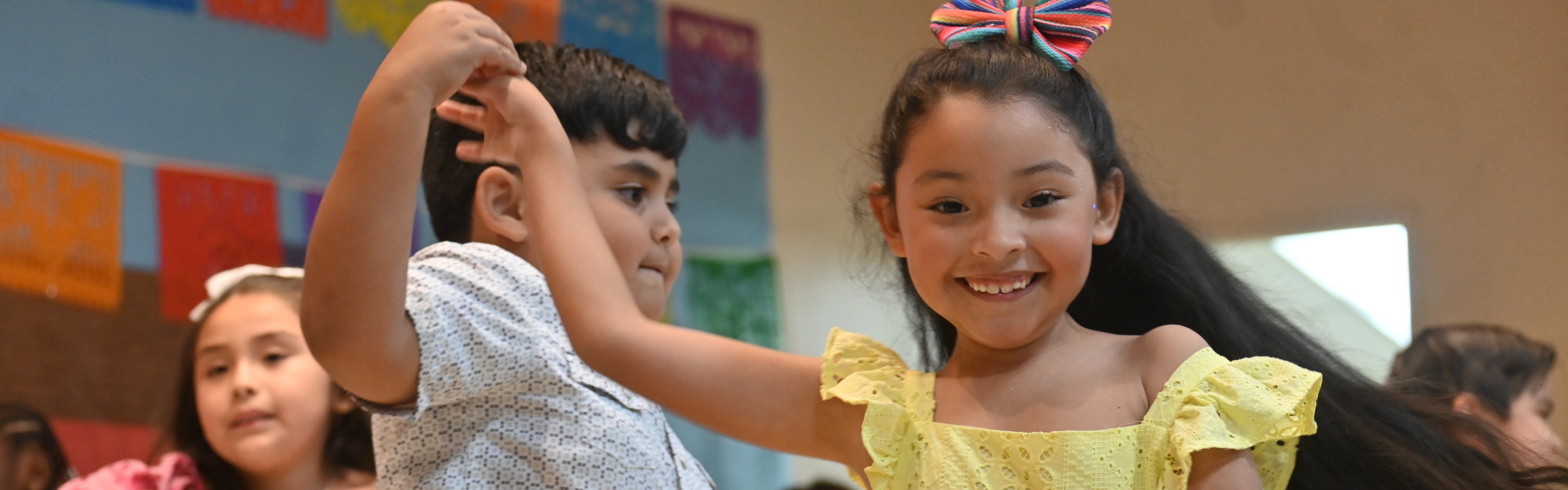 students dance on stage as part of a program for parents