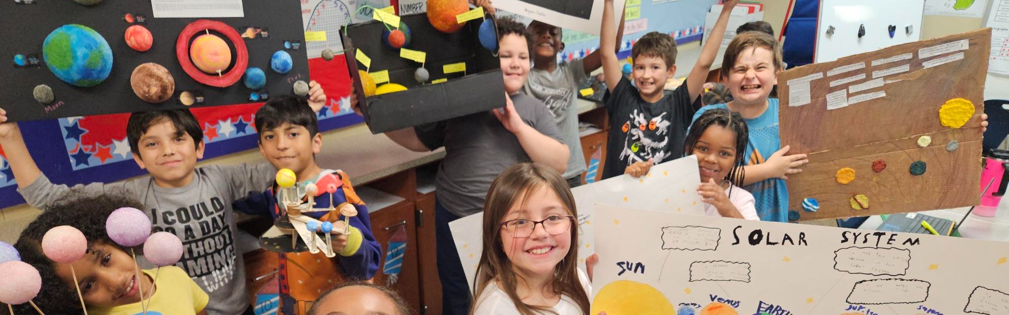 students showing off their solar system projects