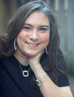 Kacy Arnold with chin resting on hand.