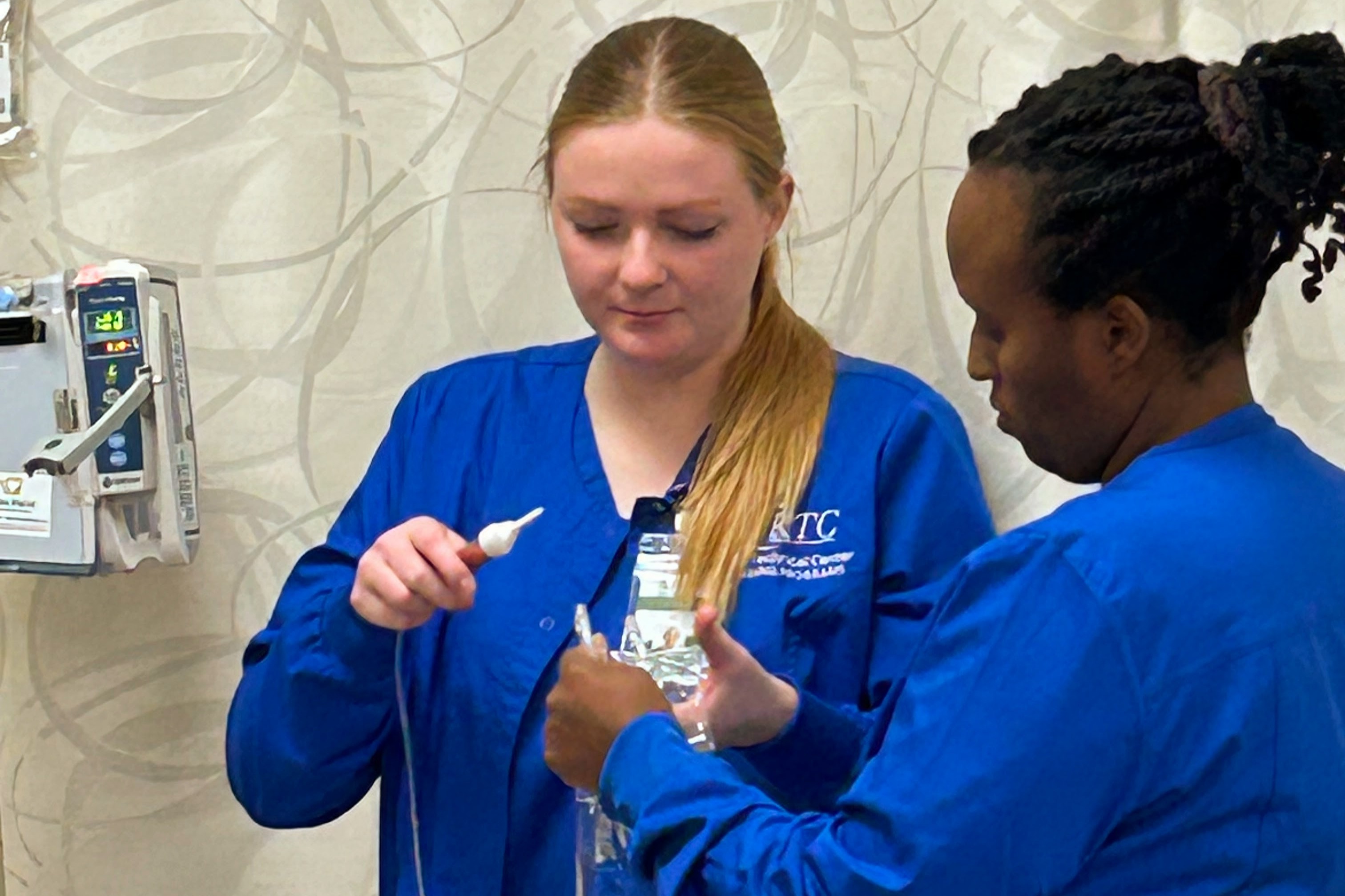 2 Nursing students holding IV bag