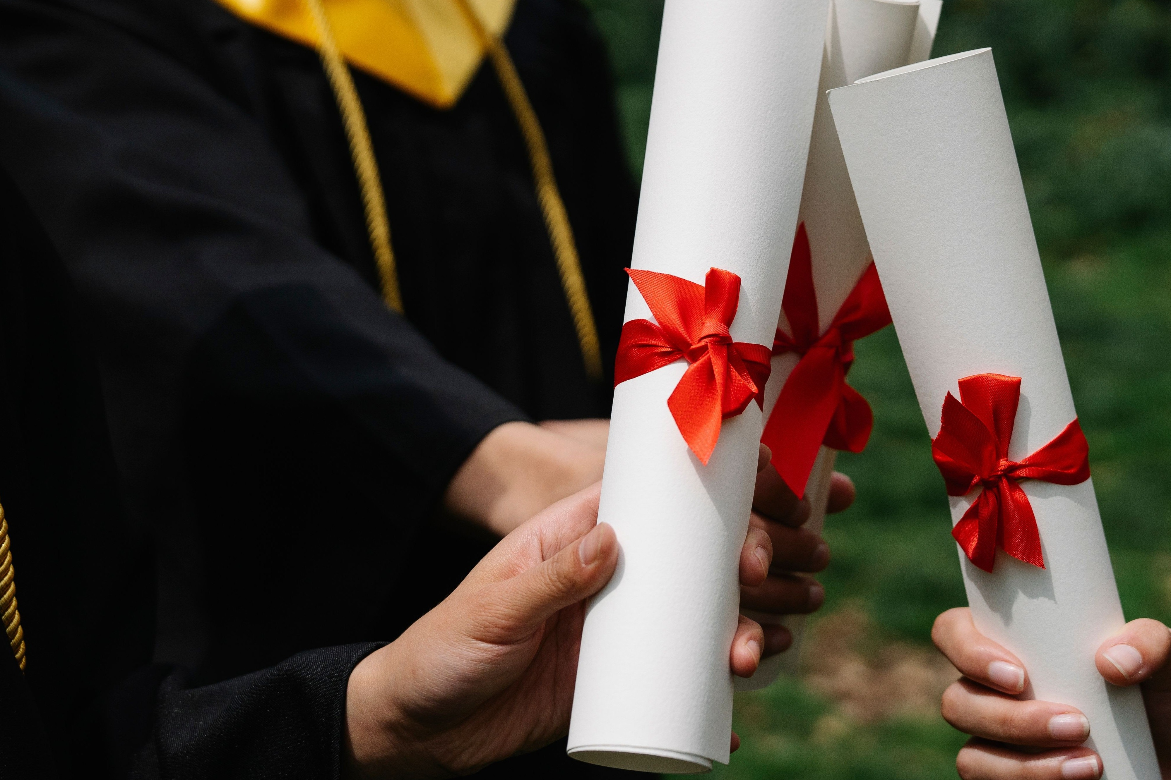 diplomas being held by graduates