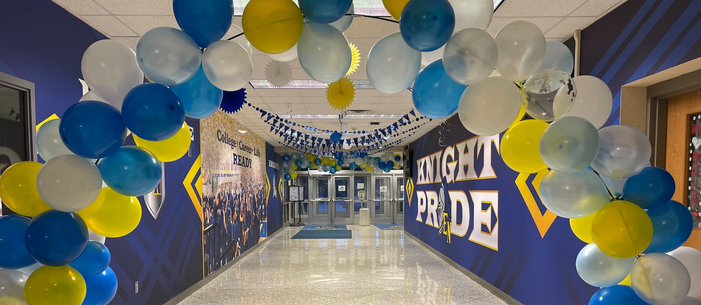 school entrance lined with yellow and blue balloons. 