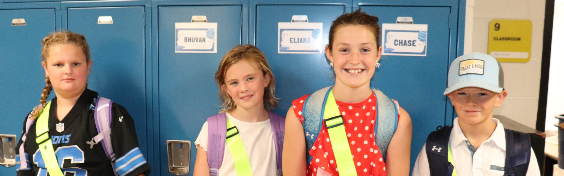 Two students standing by lockers smiling