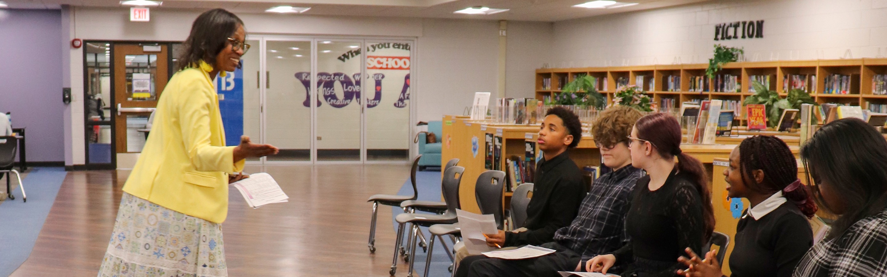 Teacher talking to students in the library