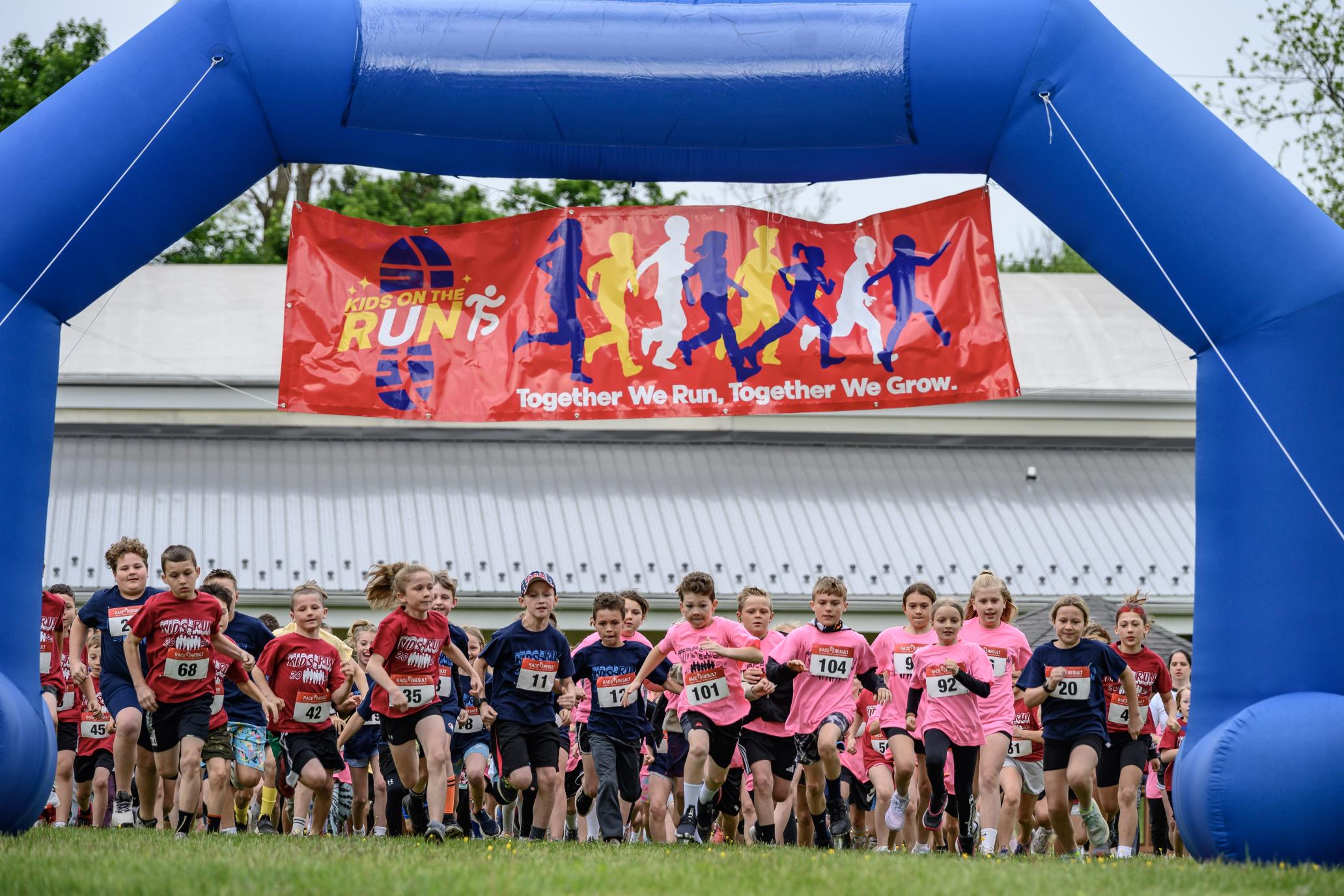 A large group of students under a banner saying "Kids on the Run"