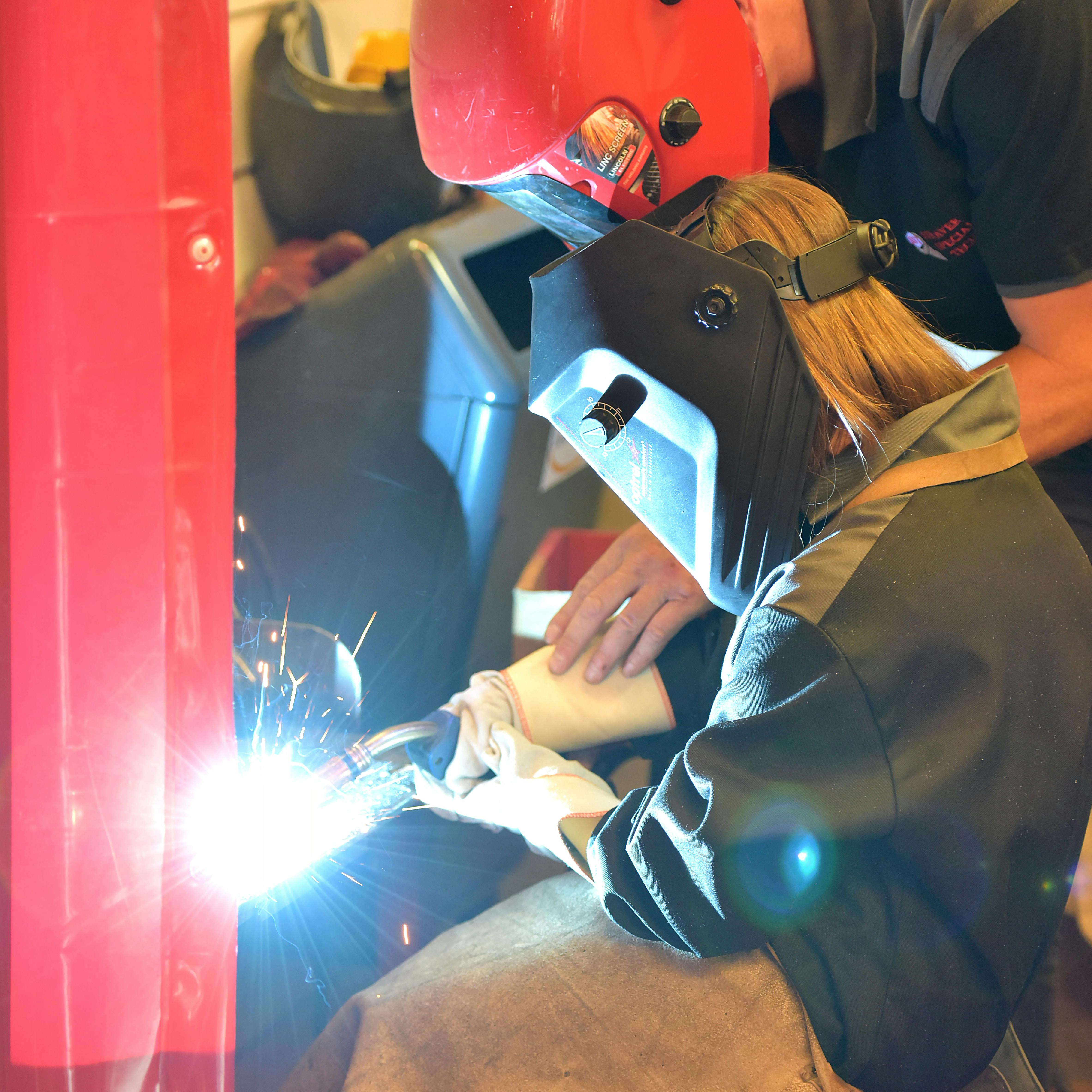 Teacher showing student how to weld
