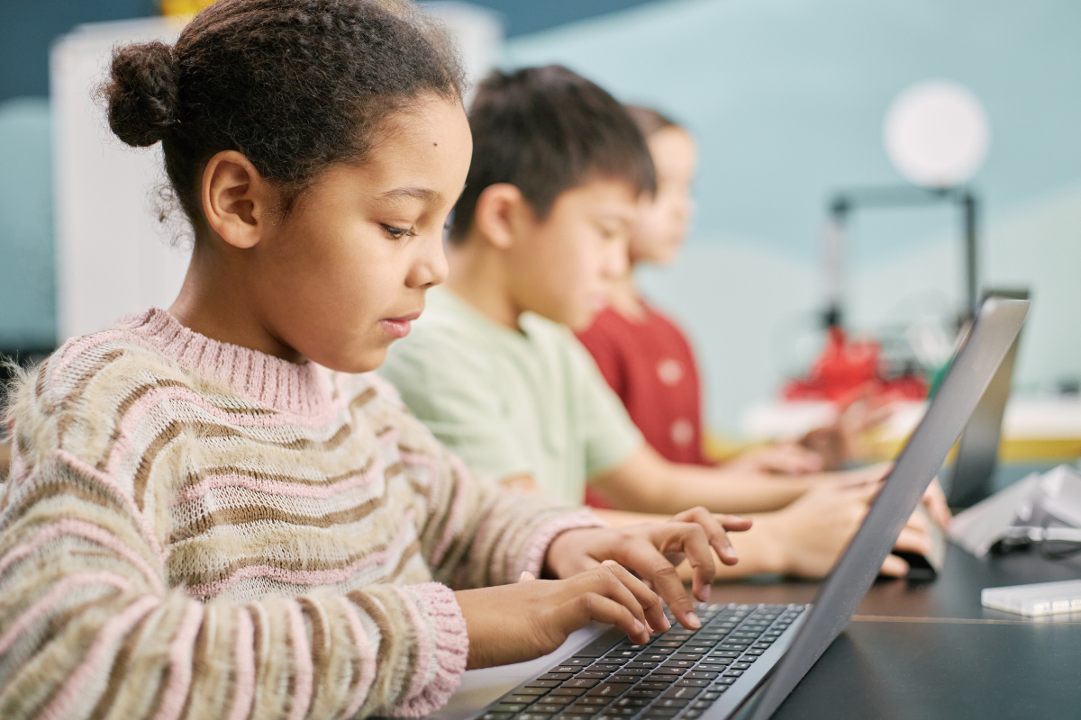 picture of 3 children doing work on a laptop