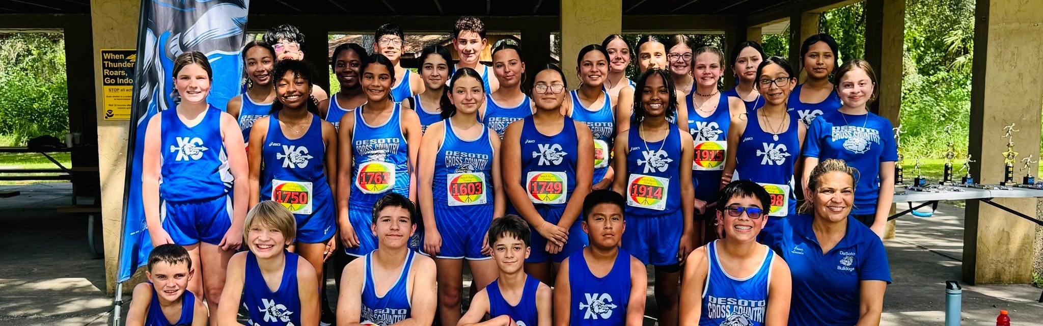 DMS cross country boys and girls posting in blue and white uniforms