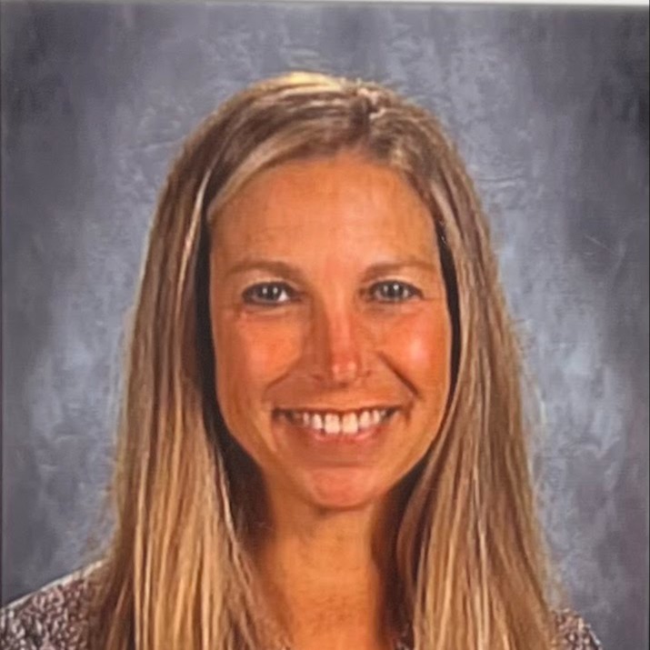 Blonde woman smiling with a grey background