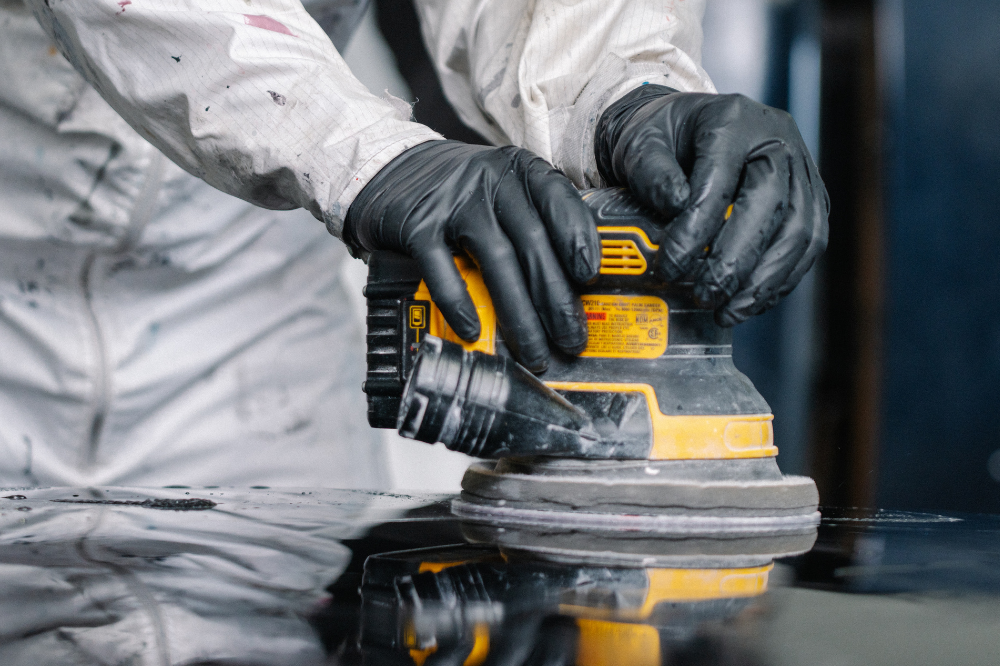 Automotive Collision student buffing a car's hood