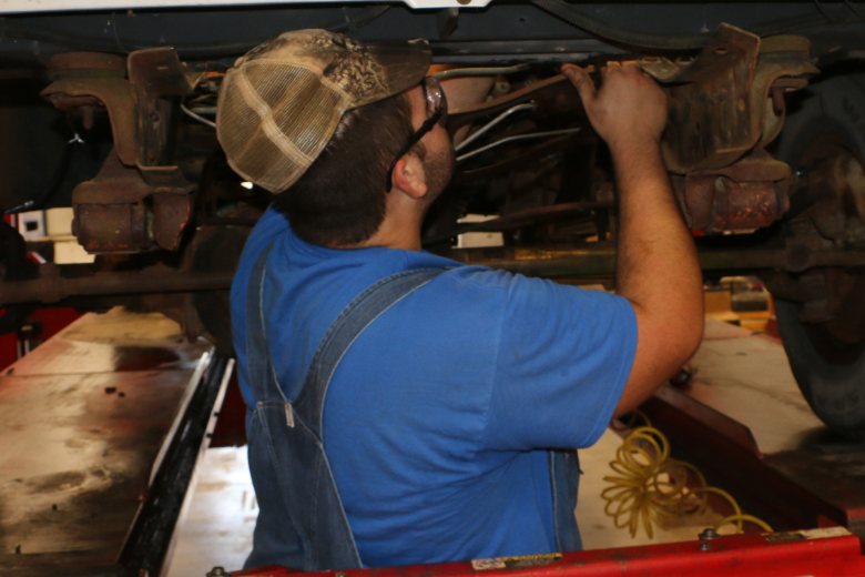 Automotive student working underneath a Chevy truck