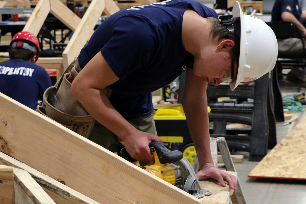 Carpentry student cutting wood with a circular saw.