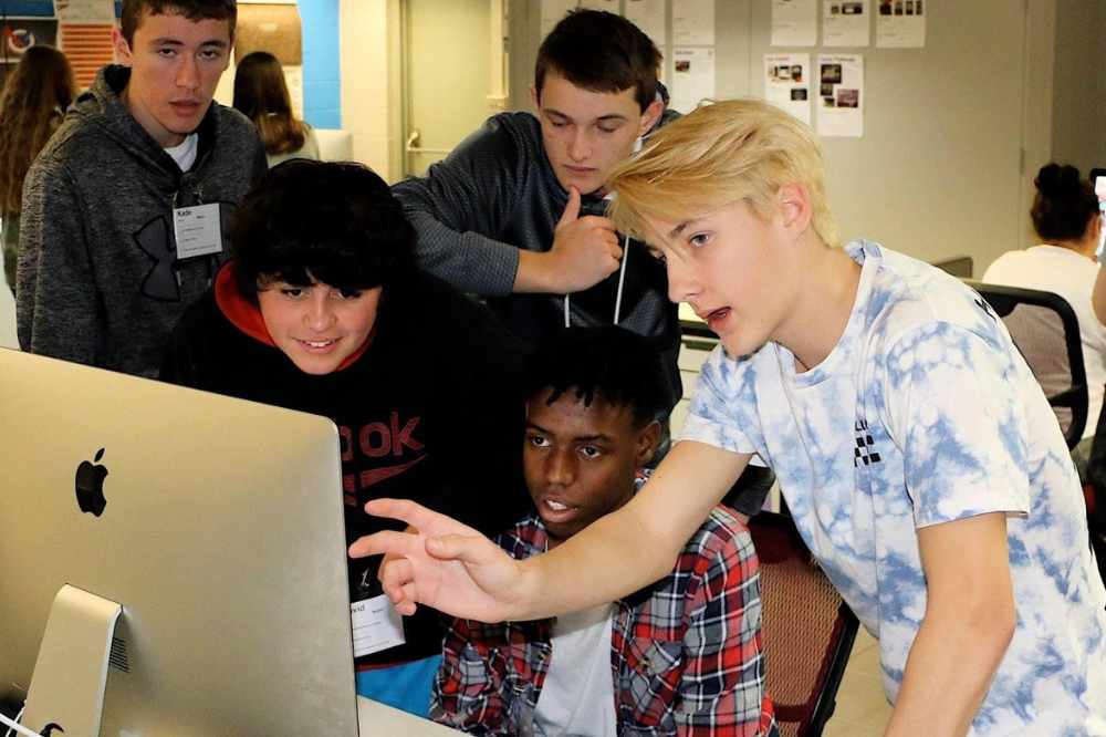 Graphic Design students look at a computer screen.