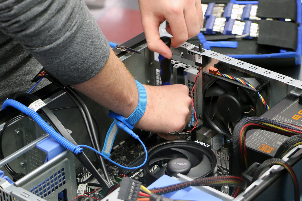 CNT student disassembling a desktop computer. 