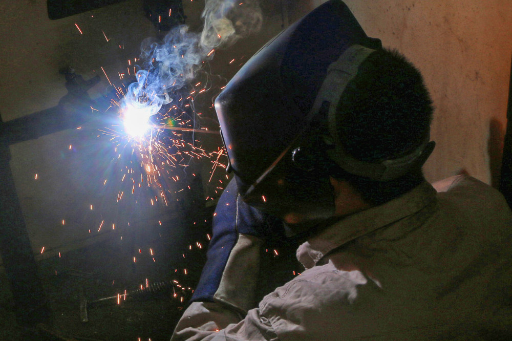 Student welding in a welding booth. 