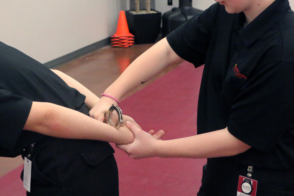 Criminal Justice & Emergency Services student demonstrates who to apply handcuffs.