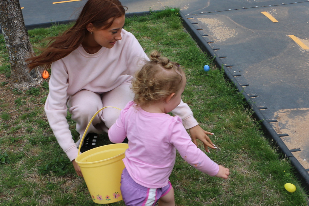 ECE student helps child hunt for Easter eggs. 