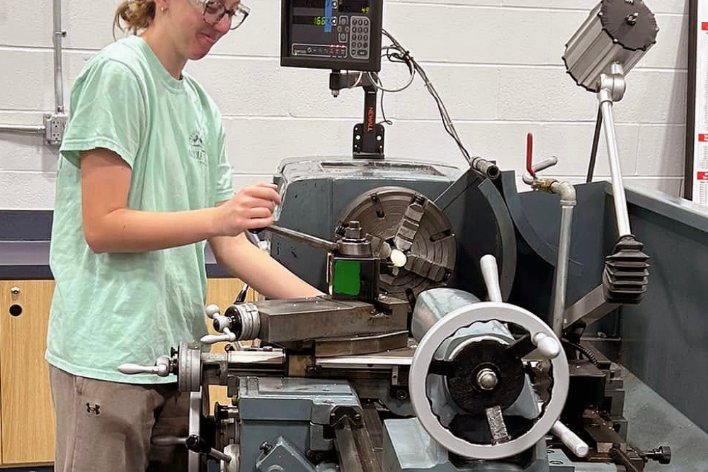 Machining student works on a manual lathe.